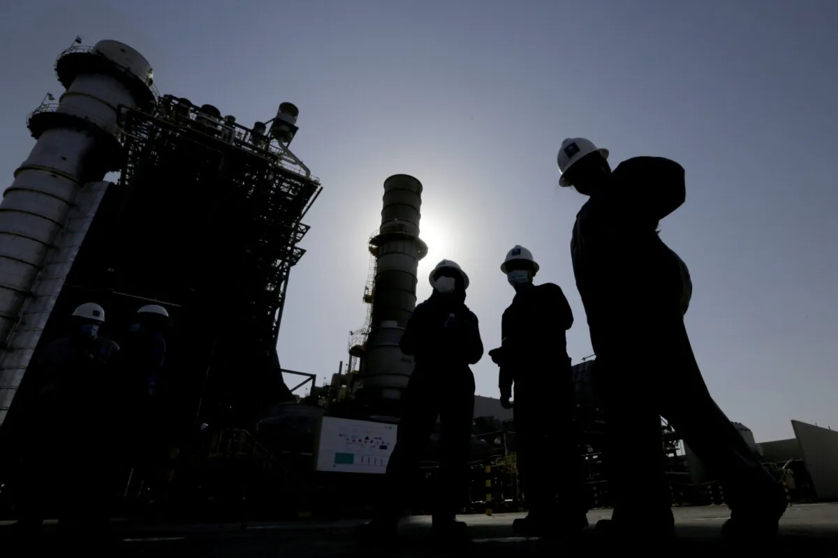 Saudi Aramco engineers walk in front of a gas turbine generator during a tour for journalists at the Khurais oil field, outside of Riyadh, Saudi Arabia, on June 28, 2021. (Amr Nabil/AP Photo)