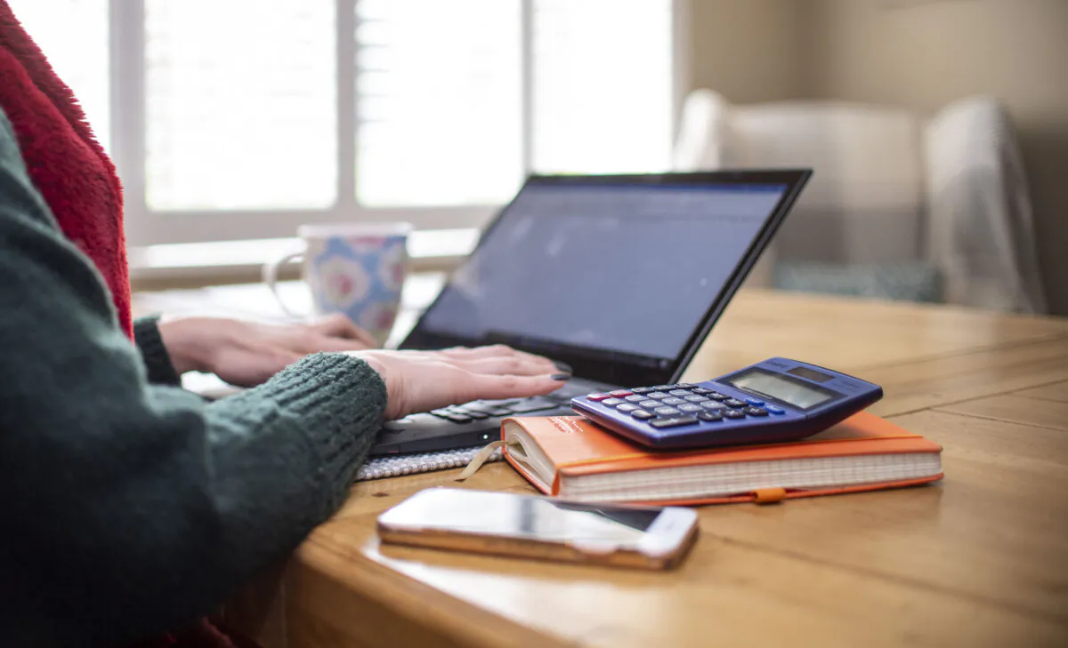 A woman using a laptop on a dining room table set up as a remote office to work from home on March 4, 2020. (Joe Giddens/PA Wire)