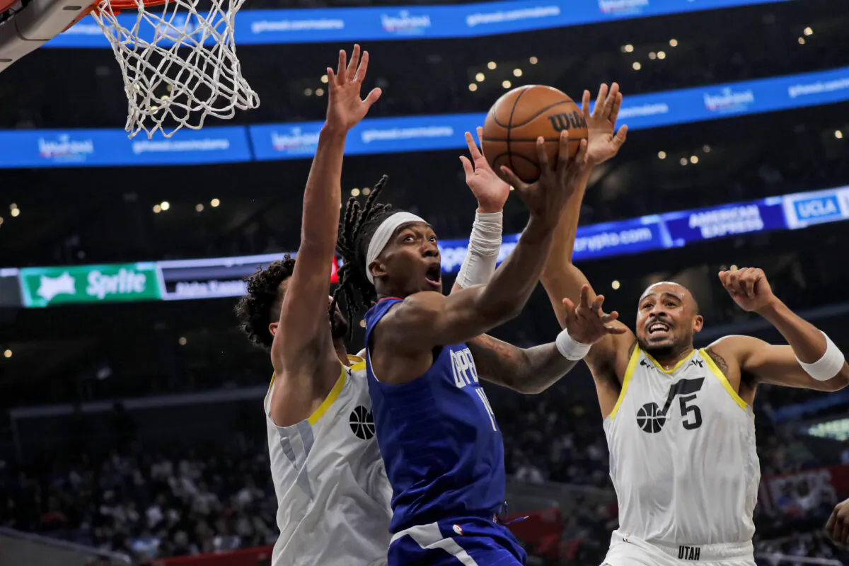 Los Angeles Clippers guard-forward Terrance Mann (C) scores against Utah Jazz guard Keyonte George (L) and guard Talen Horton-Tucker (5) during the first half of an NBA basketball game in Los Angeles on April 5, 2024. (Etienne Laurent/AP Photo)