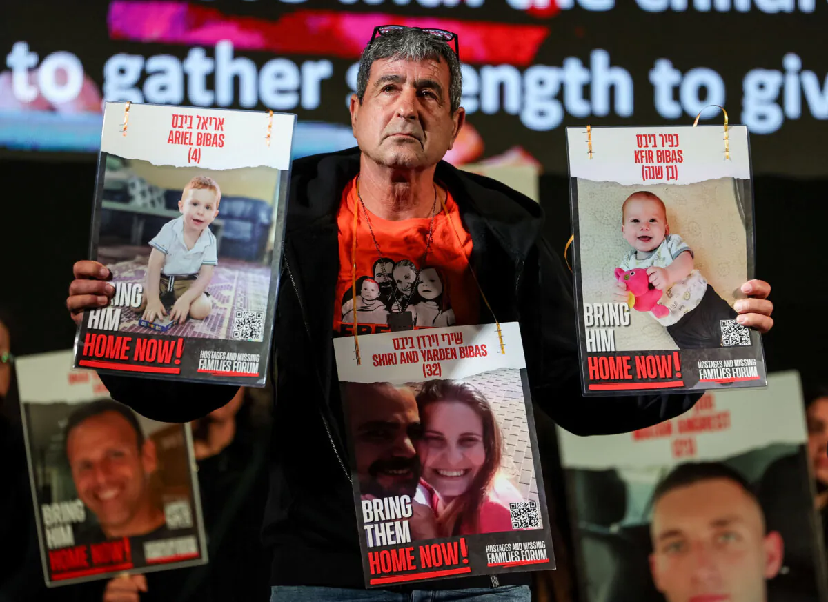 A member of the Bibas family holds pictures of Shiri, her husband Yarden, and their children Kfir and Ariel, who were kidnapped during the deadly Oct. 7 attack on Israel by the terrorist group Hamas, during a rally calling for the release of the hostages near Israel's parliament in Jerusalem on April 7, 2024. (Reuters/Ronen Zvulun)