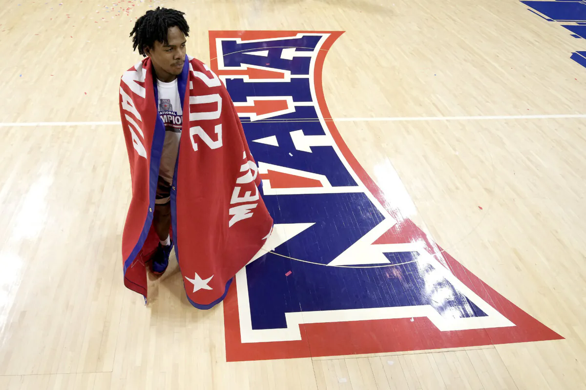 Freed-Hardeman guard Quan Lax wears the championship banner after the NAIA men's national-title basketball game against Langston in Kansas City, Mo., on March 26, 2024. (Charlie Riedel/AP Photo)