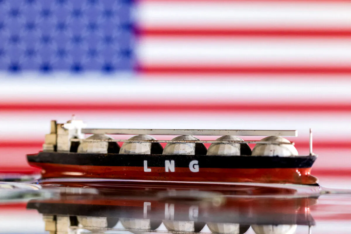 A model LNG tanker in front of a U.S. flag, in this illustration taken on May 19, 2022. (Dado Ruvic/Reuters)