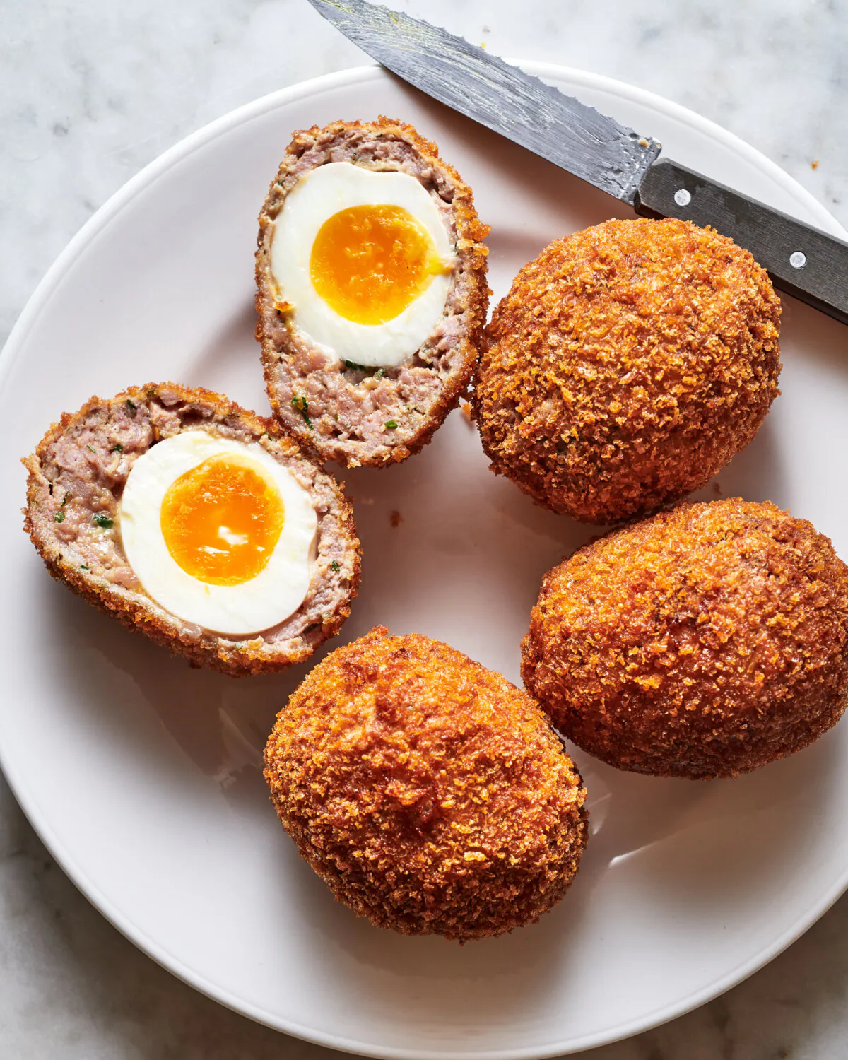 Soft-boiled eggs are wrapped in breakfast sausage, then breaded and fried for this special British snack. (Joe Lingeman/TNS)
