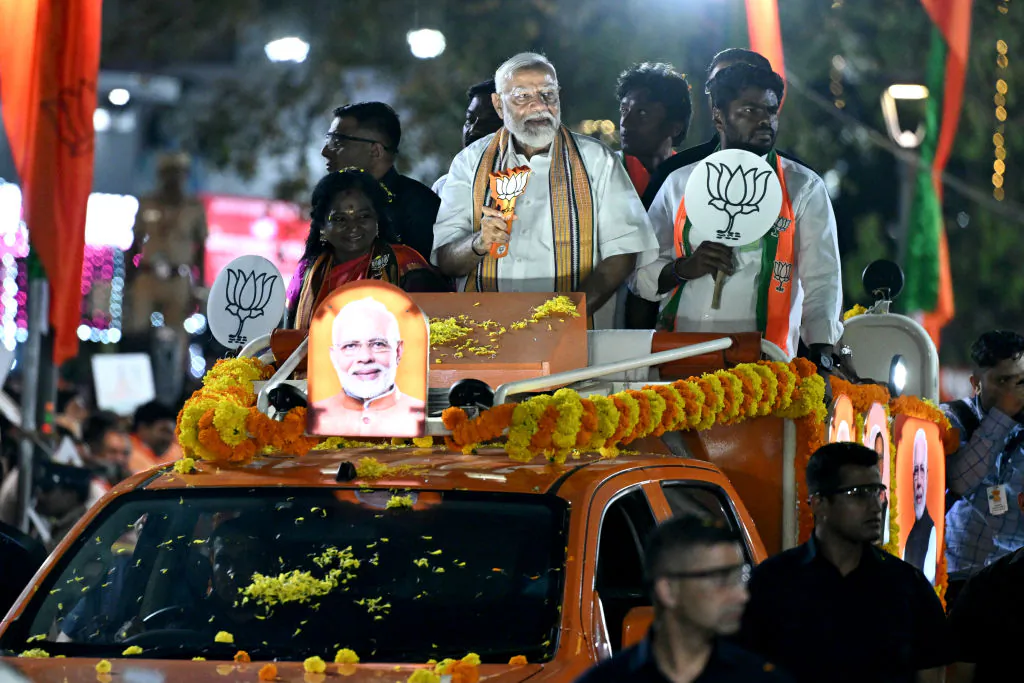 Narendra Modi (C), India's Prime Minister and leader of the ruling Bharatiya Janata Party (BJP) holds the party symbol during a campaign road show in Chennai on April 9, 2024. (R. Satish Babu / AFP via Getty Images)