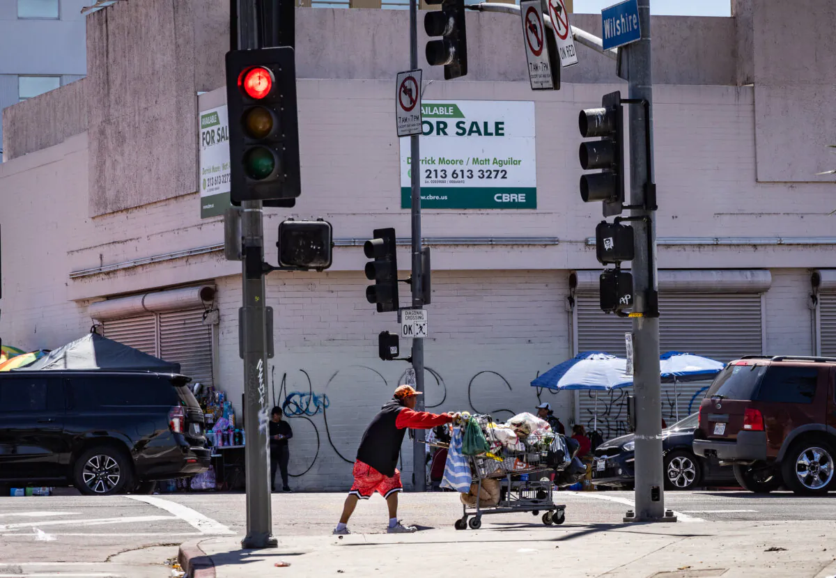 A homeless man pushes a shopping cart in Los Angeles, Calif., on April 10, 2024. (John Fredricks/The Epoch Times)