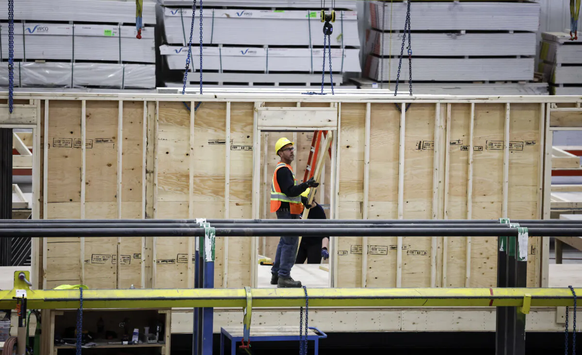 An employee works on a modular home component in Calgary on April 5, 2024. (The Canadian Press/Jeff McIntosh)