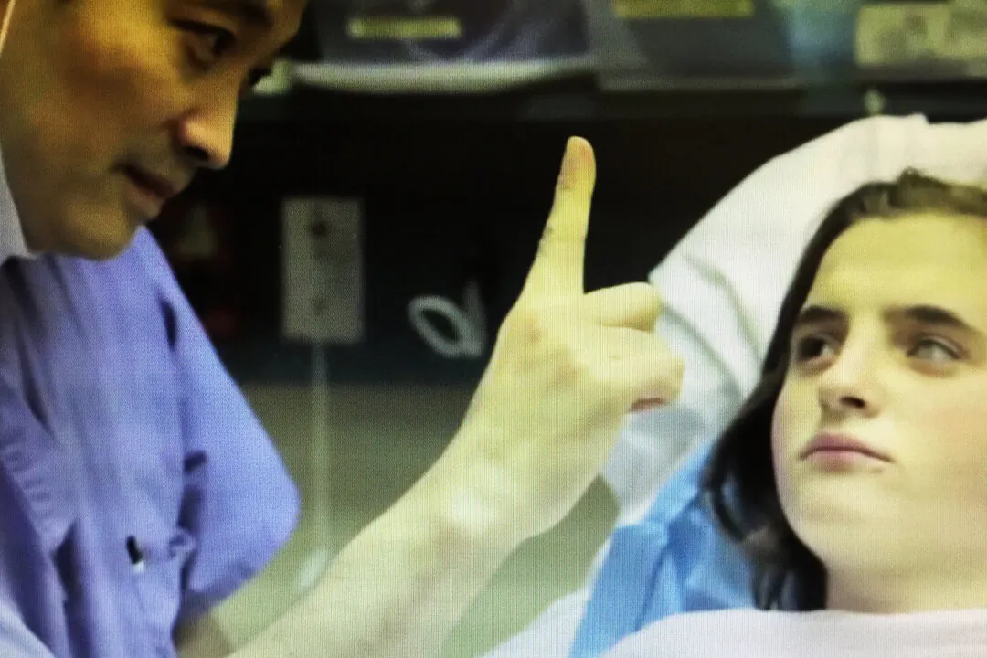 After surgery, Dr. Ming Wang lifted one finger and asked Maria Morari how many he was holding up. Maria, who had been blind, replied, "Unu"—Romanian for "one." (Courtesy of Dr. Ming Wang)
