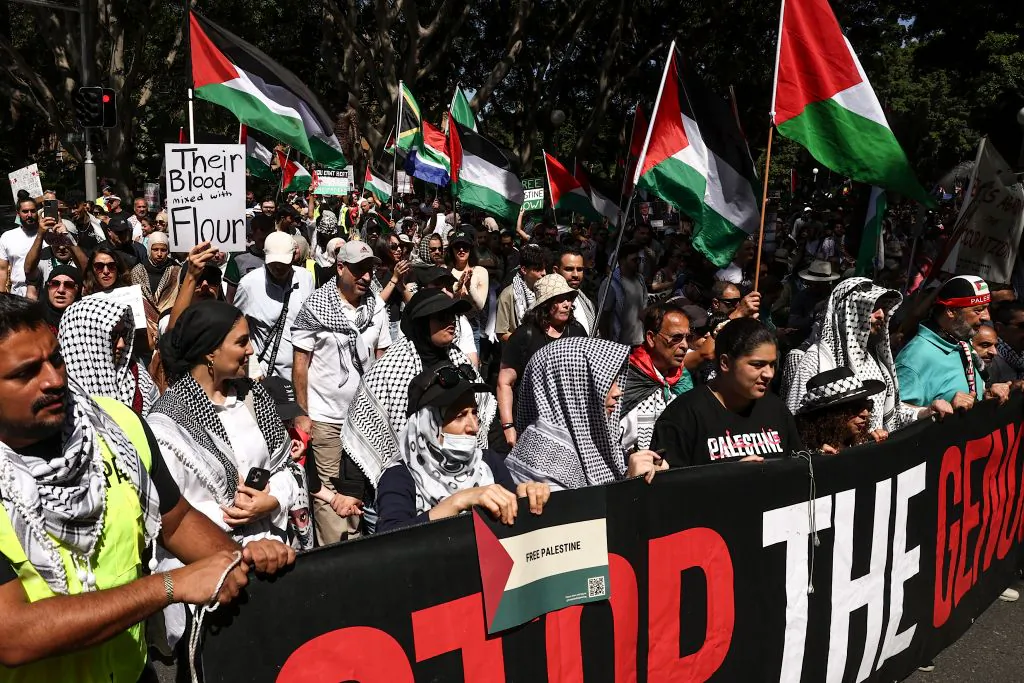 Members of the Australian Palestinian community and supporters wave Palestinian flags as others hold placards and banners during a protest in central Sydney on March 3, 2024. (Photo by DAVID GRAY / AFP) (Photo by DAVID GRAY/AFP via Getty Images)