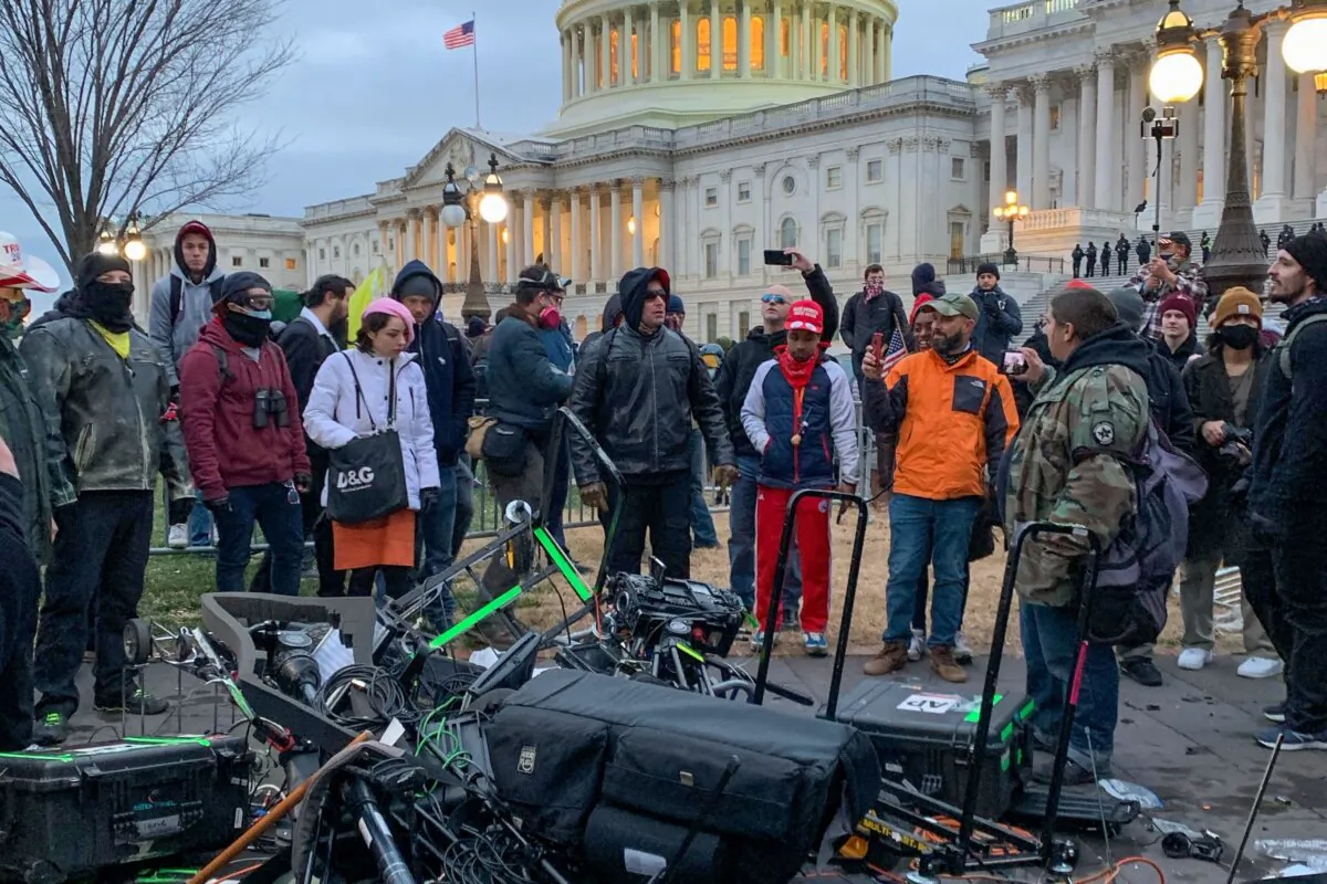 People stand around destroyed media equipment outside the U.S. Capitol in Washington D.C. on January 6, 2021 (Camille Camdessus/AFP via Getty Images)
