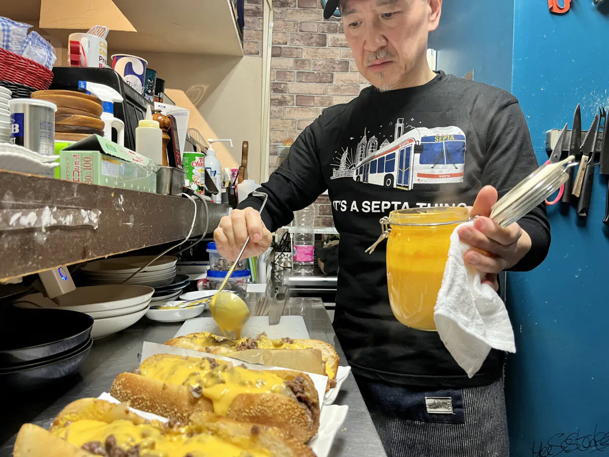 Kosuke Chujo ladles homemade cheese sauce onto cheesesteaks at Nihonbashi Philly. (Jenn Ladd/The Philadelphia Inquirer/TNS)