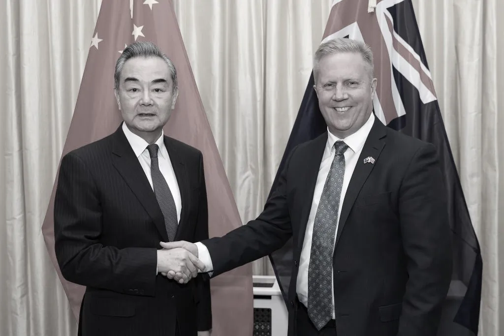 Chinese Foreign Affairs Minister Wang Yi and New Zealand Trade Minister Todd McClay shake hands before a meeting at Parliament in Wellington, New Zealand, on March 18, 2024. (Hagen Hopkins/Getty Images)
