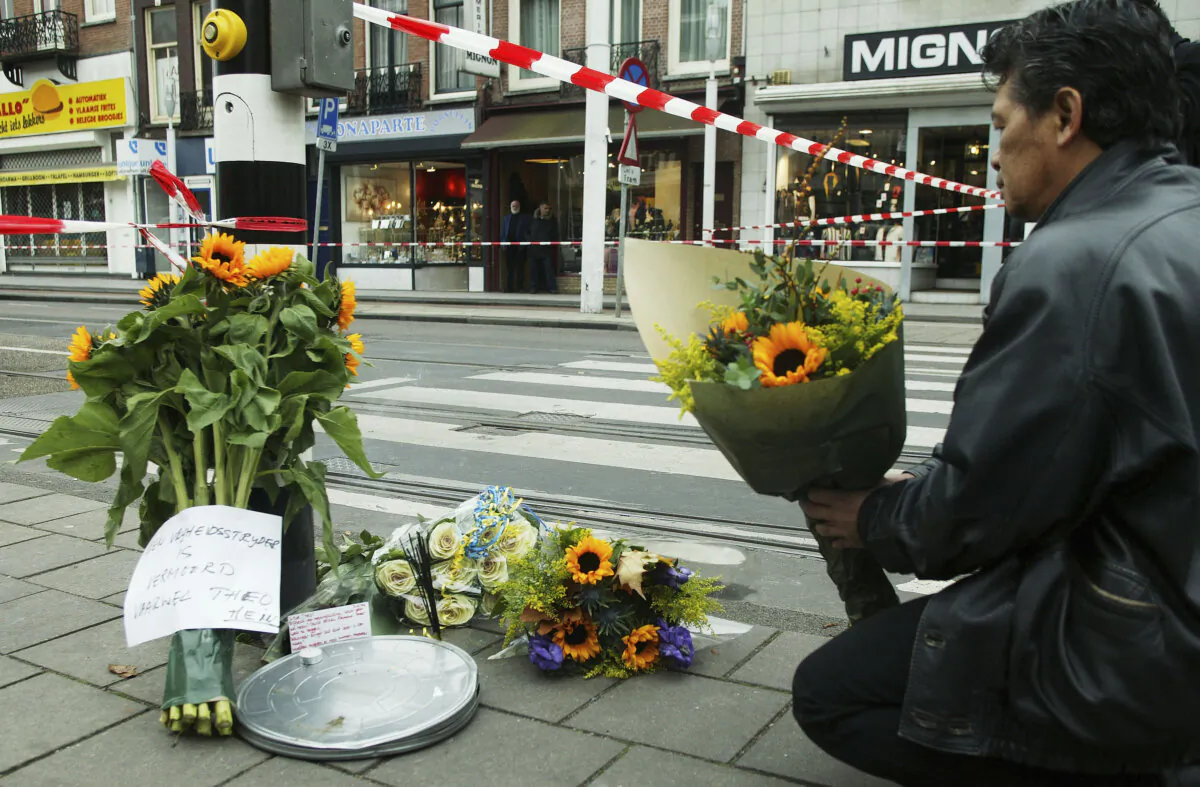 A man places flowers near the crime scene where Dutch filmmaker Theo van Gogh was murdered in Amsterdam, Netherlands, on Nov. 2, 2004. (Michel Porro/Getty Images)
