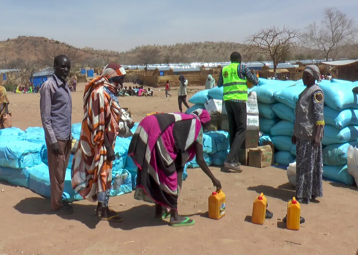 Sudanese refugees displaced by the conflict in Sudan gather to receive food staples from aid agencies at the Metche Camp in eastern Chad on March 5, 2024. (The Canadian Press/AP-Jsarh Ngarndey Ulrish)