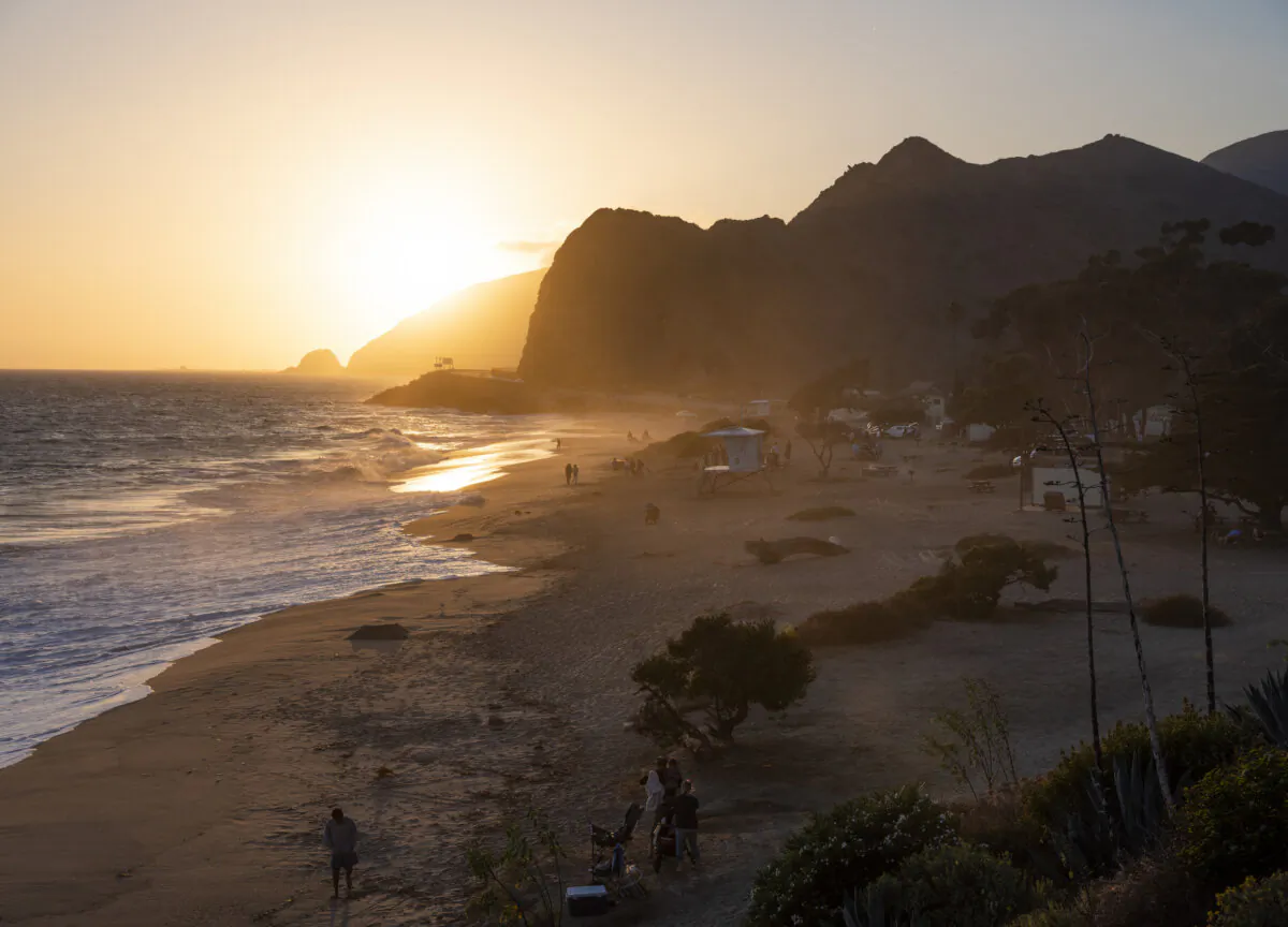 Beachgoers catch the last of the sunset light in the ocean alongside the Pacific Coast Highway on July 2, 2020. (Brent Stirton/Getty Images)