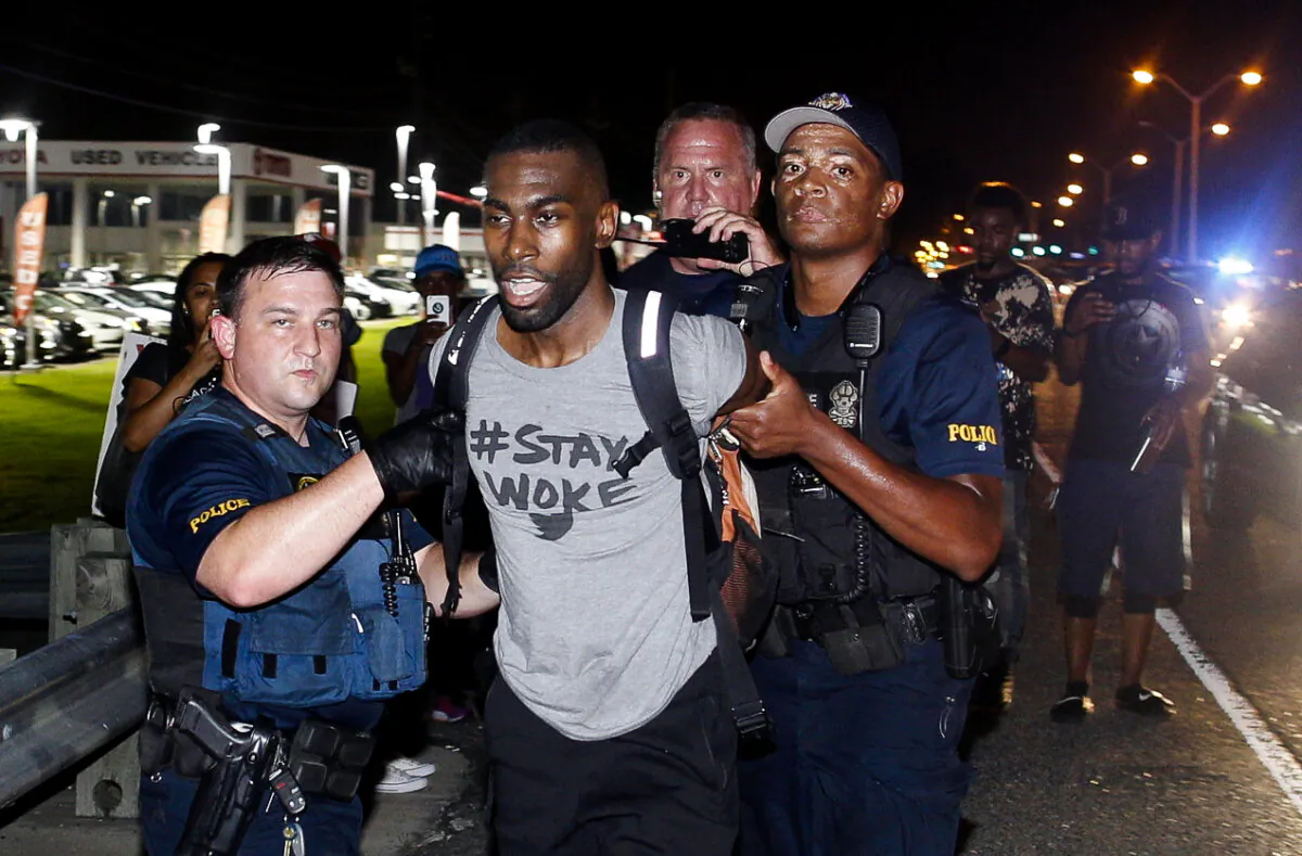 Police arrest activist DeRay Mckesson during a protest along Airline Highway, a major road that passes in front of the Baton Rouge Police Department headquarters in Baton Rouge, La., on July 9, 2016. (AP Photo/Max Becherer)