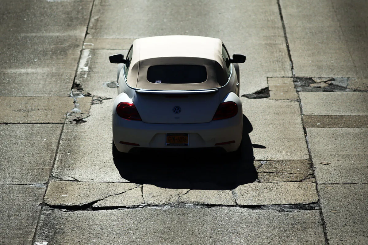 A car travels over a section of highway riddled with potholes in the Brooklyn borough of New York City in a file photo. (Spencer Platt/Getty Images)