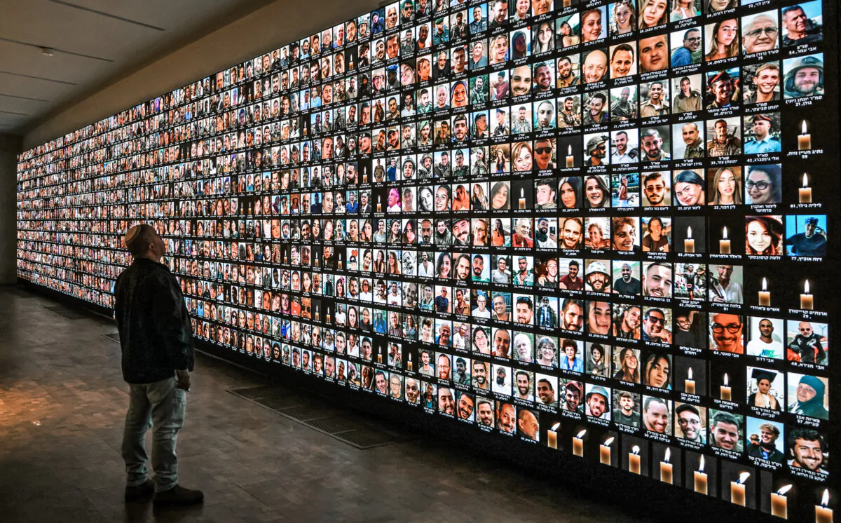 A visitor looks at a giant backlight screen bearing the portraits of Israelis who were killed during the Oct. 7, 2023, attacks by Hamas or who died during the ongoing battles between Israel and the Palestinian terrorist group, at the National Library in Jerusalem on Jan. 25, 2024. (Ahmad Gharabli/AFP via Getty Images)