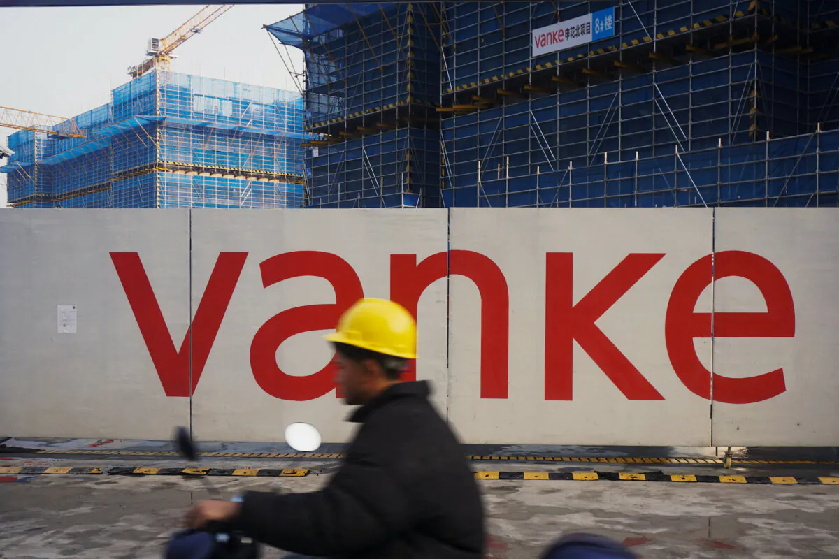 A worker driving past residential buildings under construction by Chinese real estate developer Vanke in Hangzhou, in eastern China's Zhejiang Province, on March 31, 2024. (STR/AFP via Getty Images)
