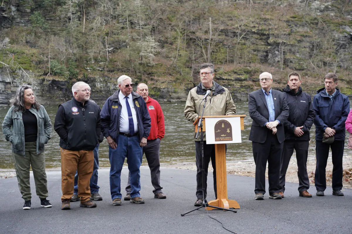Flanked by municipal and county officials, Orange County Land Trust Executive Director Jim Delaune (C) talks about a major land preservation campaign in Sparrow Bush, N.Y., on April 18, 2024. (Cara Ding/The Epoch Times)