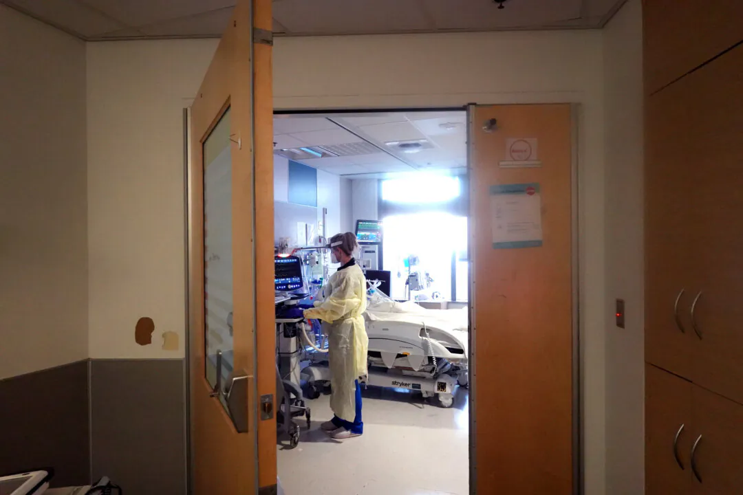 A respiratory therapist checks on a COVID-19 patient in the intensive care unit at Rush University Medial Center in Chicago on Jan. 31, 2022. (Scott Olson/Getty Images)