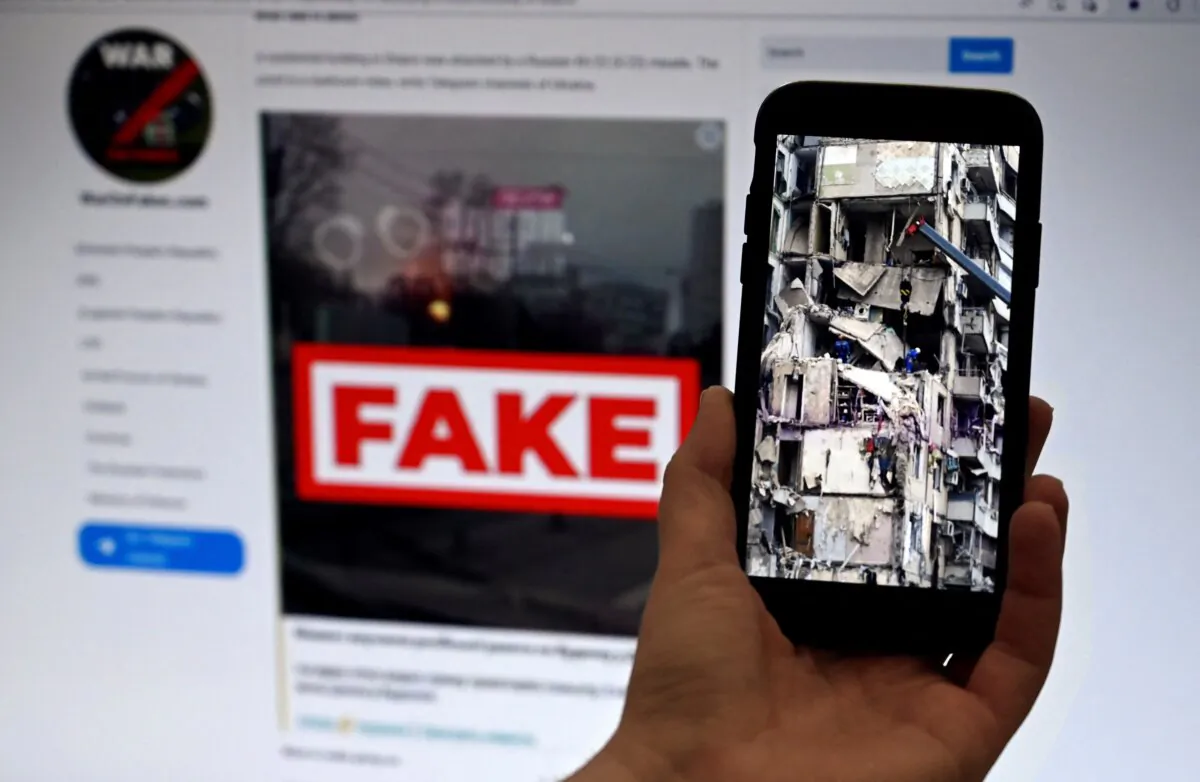 This illustration photo shows a phone displaying a picture of rescuers working on a residential building destroyed after a missile strike in Dnipro on Jan. 16, 2023, with the WarOnFakes.com website displaying a fake video of the same residential building shown in the background, taken on Feb. 14, 2023. (Olivier Douliery/AFP via Getty Images)