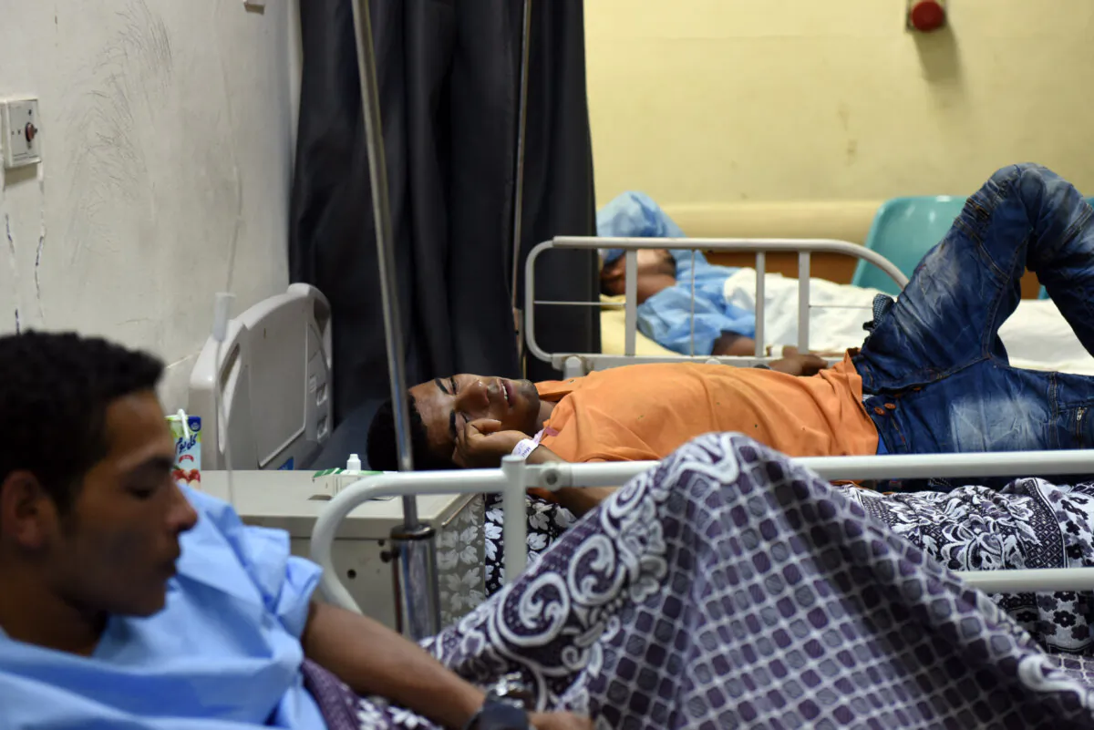 Rescued immigrant Wael Mahmoud Mohammed (C), lies in bed with other survivors at Rashid Hospital in Rosetta, northern Egypt, on Sept. 21, 2016, after a boat capsized in the Mediterranean off Egypt's north coast, drowning 42 people. (Mohamed El-Shahed/AFP via Getty Images)