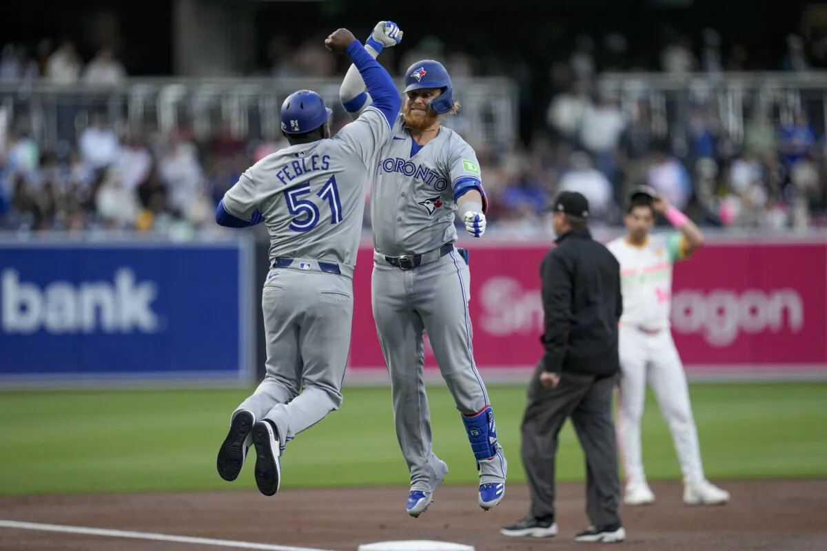 Toronto Blue Jays designated hitter Justin Turner (C) celebrates with third base coach Carlos Febles (51) after hitting a home run during the first inning of a baseball game against the San Diego Padres in San Diego April 19, 2024. (Gregory Bull/AP Photo)