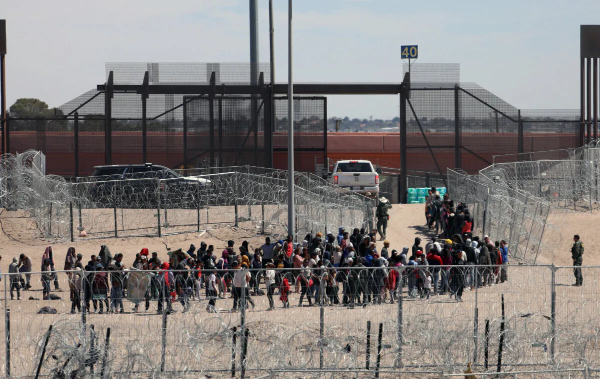 Migrants line up to be transferred by U.S. Border Patrol after having crossed the Bravo River in El Paso, Texas, as seen from Ciudad Juarez, Chihuahua State, Mexico, on April 18, 2024. (Herika Martinez/AFP via Getty Images)
