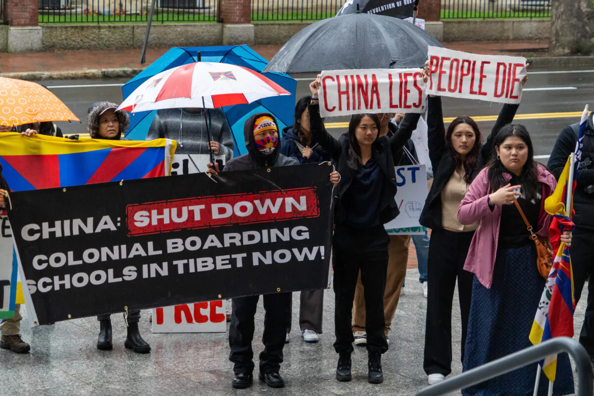 Protesters held banners and placards bearing messages at Harvard Kennedy School in Cambridge, Mass., on April 20, 2024. (Learner Liu/The Epoch Times)
