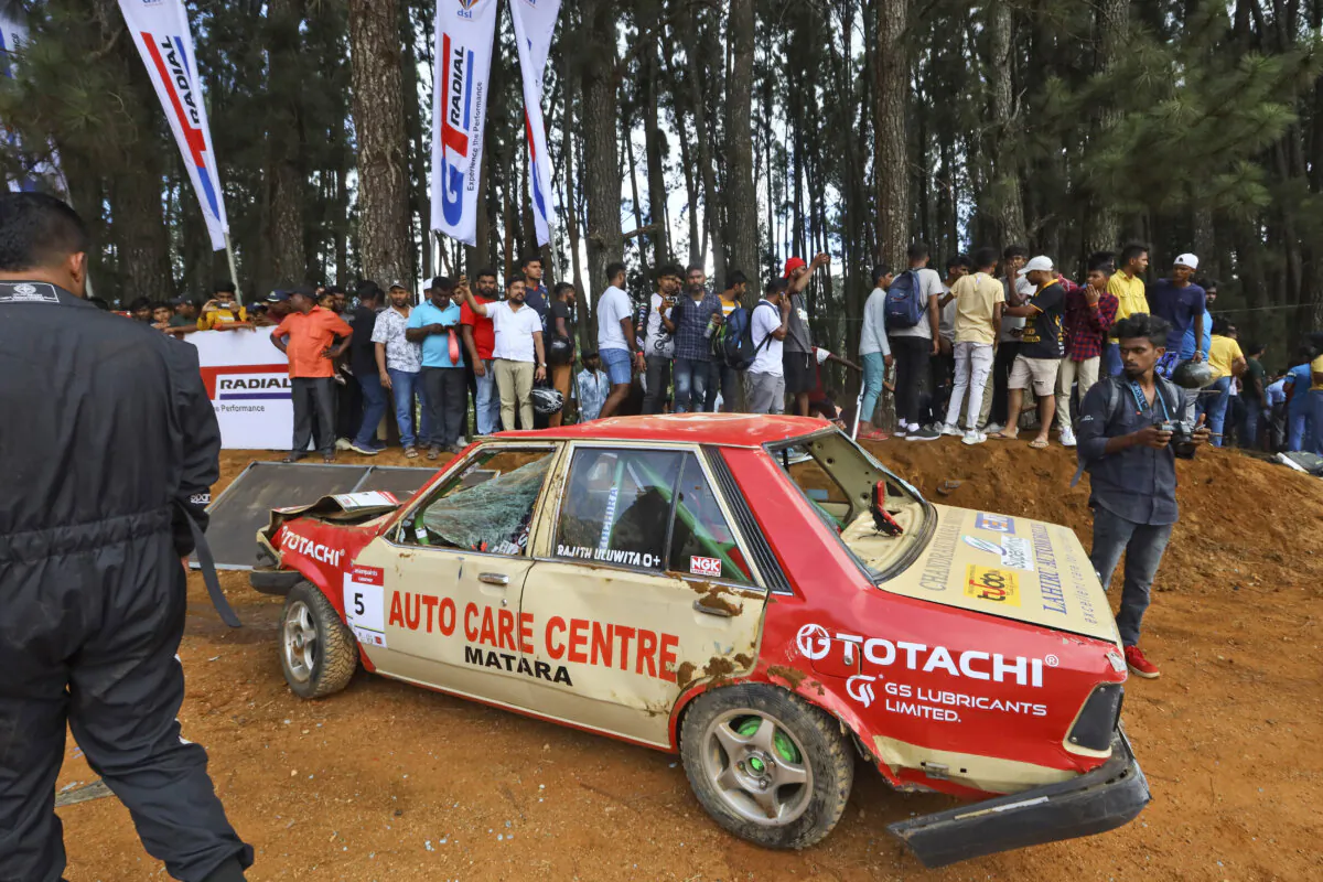 People gather around a car that had crashed into the spectators during the Fox Hill Supercross, a motor racing event organized by the Sri Lanka's army, in Diyatalawa, Sri Lanka, on April 21, 2024. (STR/AP Photo)