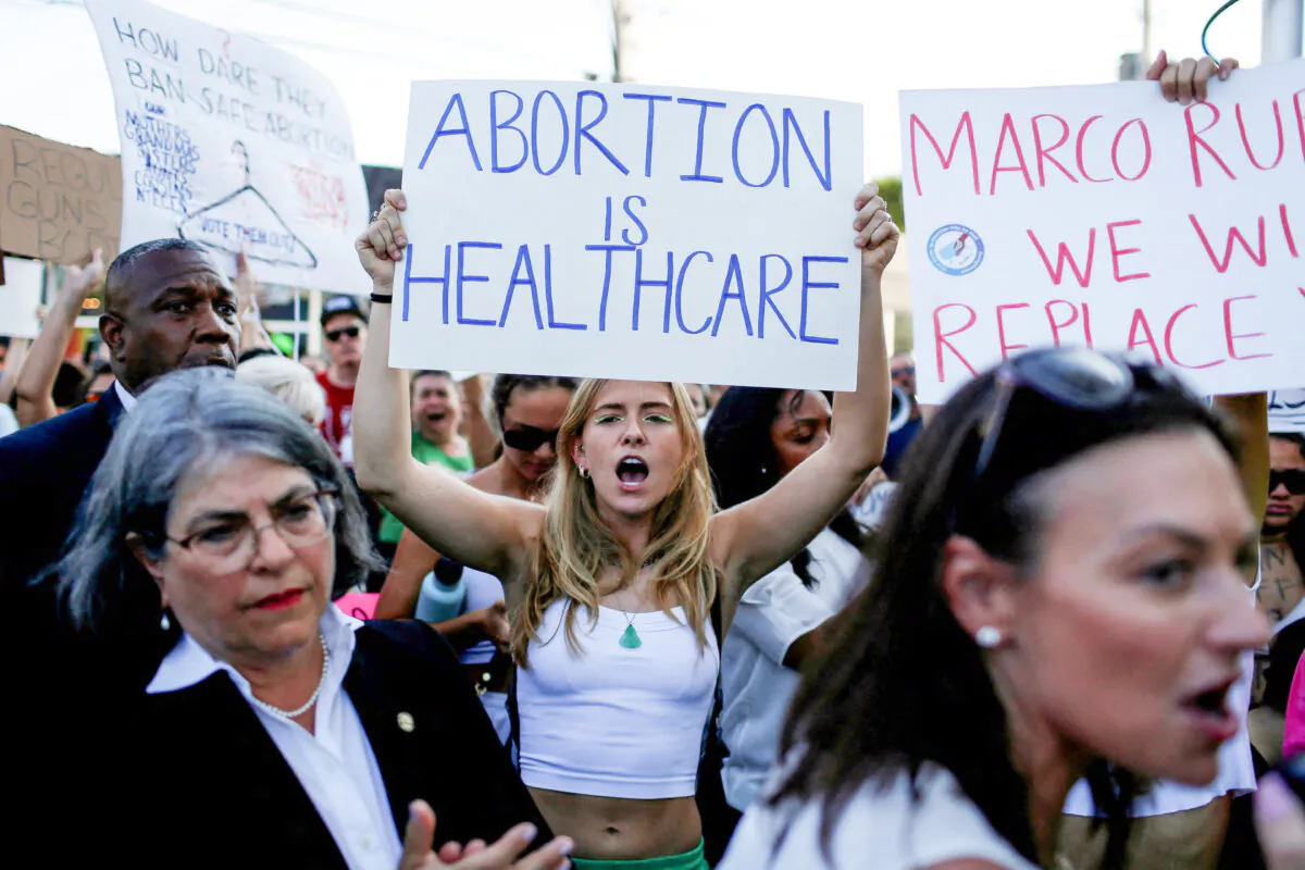 A protester holds a sign as she demonstrates in Miami after the U.S. Supreme Court ruled in the Dobbs v. Jackson Women’s Health Organization abortion case, overturning the landmark Roe v. Wade abortion decision, on June 24, 2022. (Marco Bello/Reuters)