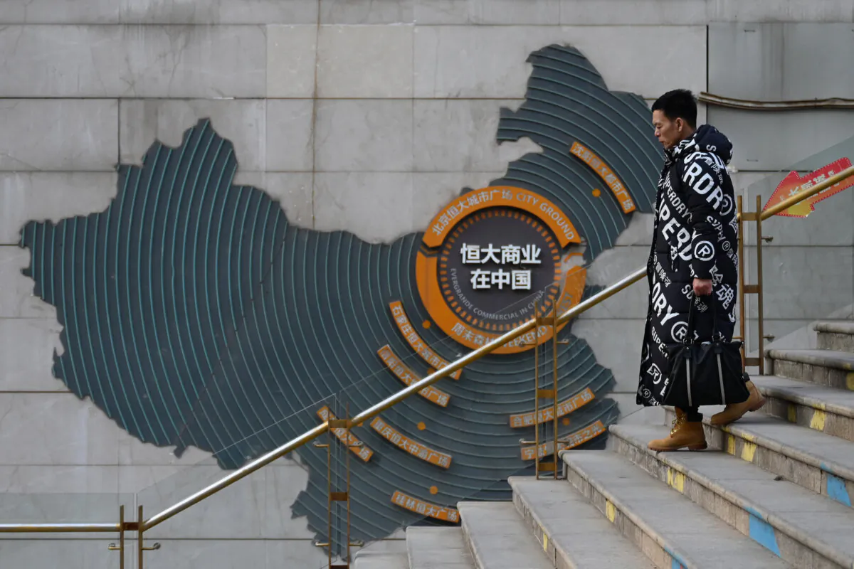 A man walks past a map of China, which shows Evergrande commercial complexes at the company's partially operating commercial complex in Beijing on Jan. 29, 2024. (Greg Baker/AFP via Getty Images)