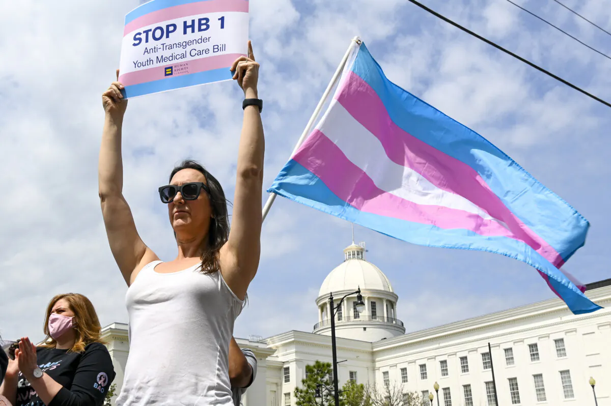 A woman holds a sign during a March 30, 2021, rally in Montgomery, Alabama, at the Alabama State House to draw attention to anti-transgender legislation. Leftist lawyers seeking to get that state law overturned engaged in unethical judge-shopping in hopes of getting one ideologically predisposed to siding with them. (Julie Bennett/Getty Images)