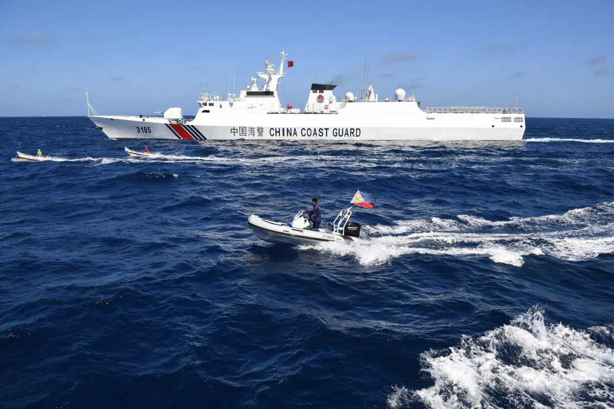 A China Coast Guard ship (top) sails dangerously close to Filipino fishermen aboard two wooden boats (center), as a Philippine Fisheries and Aquatic Resources inflatable boat observes, near the Scarborough Shoal, in the South China Sea, on Feb. 16, 2024. (Ted Aljibe/ AFP/Getty Images)