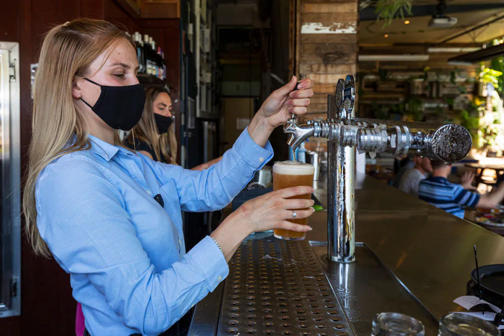 Bar staff are seen pulling a beer at College Lawn Hotel in Prahran on October 28, 2020 in Melbourne, Australia.  (Photo by Daniel Pockett/Getty Images)