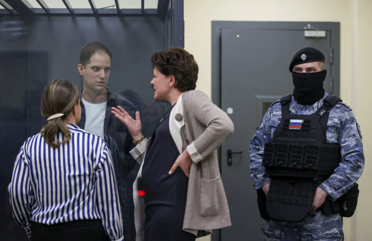 Wall Street Journal reporter Evan Gershkovich speaks with his lawyers while standing behind a glass wall of an enclosure for defendants before a court hearing in Moscow, Russia, on April 23, 2024. (Tatyana Makeyeva/Reuters)