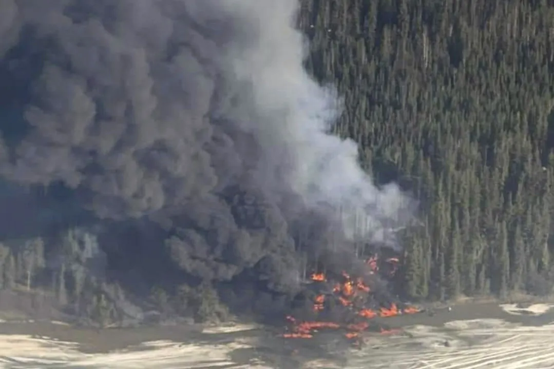 A fire burns after a Douglas C-54 Skymaster plane crashed into the Tanana River outside Fairbanks, Alaska, on April 23, 2024. (Michaela Matherne via AP)