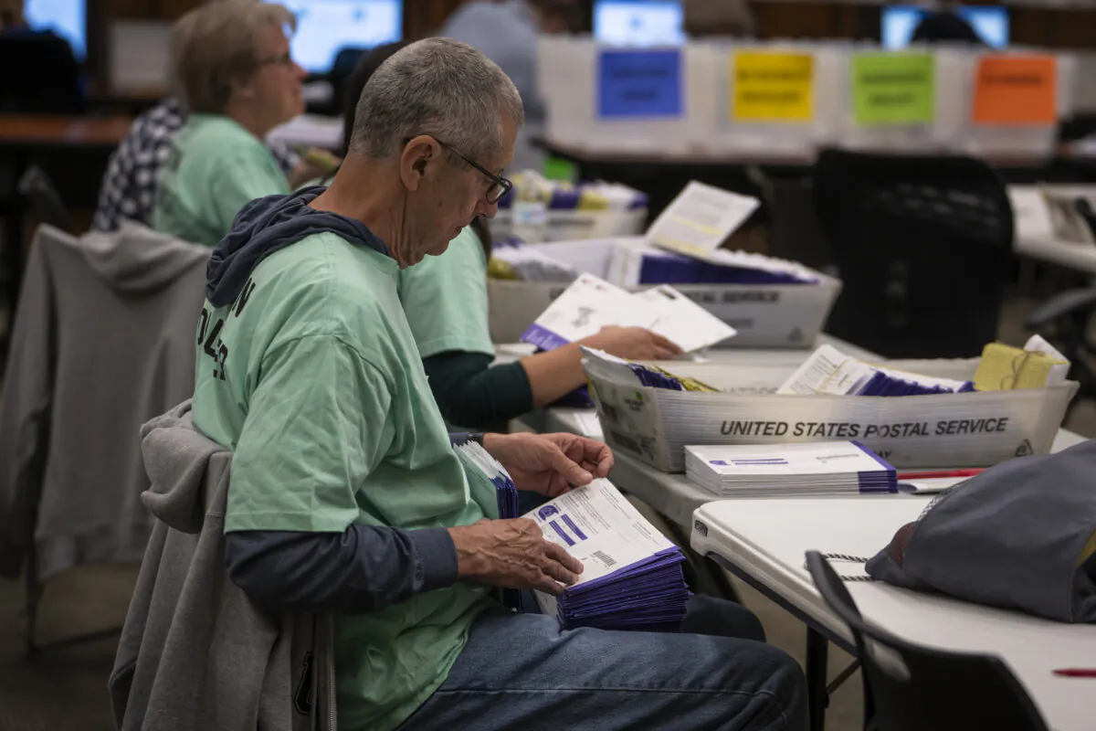 An election volunteer prepares mail-in ballots for scanning at the Lancaster County Government Center in Lancaster, Pa., on April 23, 2024. (Madalina Vasiliu/The Epoch Times)