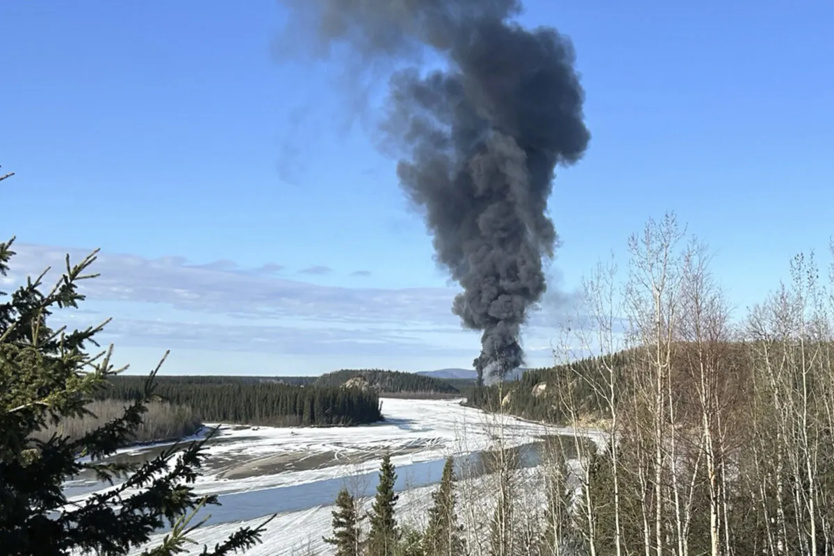 Smoke rises after a Douglas C-54 Skymaster plane crashed into the Tanana River outside Fairbanks, Alaska on April 23, 2024. (Gary Contento via AP)