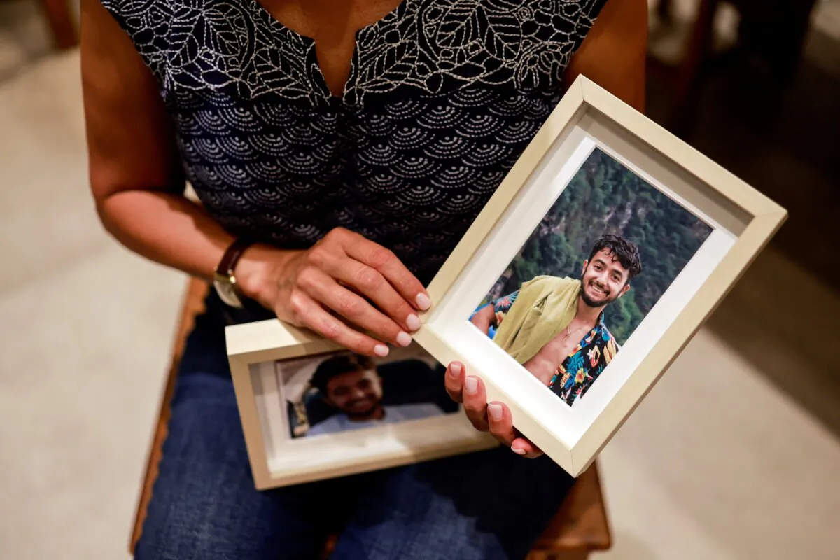 Rachel Goldberg, U.S.-Israeli mother of Hersh Goldberg Polin, which was taken hostage by Hamas militants into the Gaza Strip while attending a music festival in south Israel, holds photos of her son in their home, in Jerusalem on Oct. 17, 2023 (Ammar Awad/Reuters)
