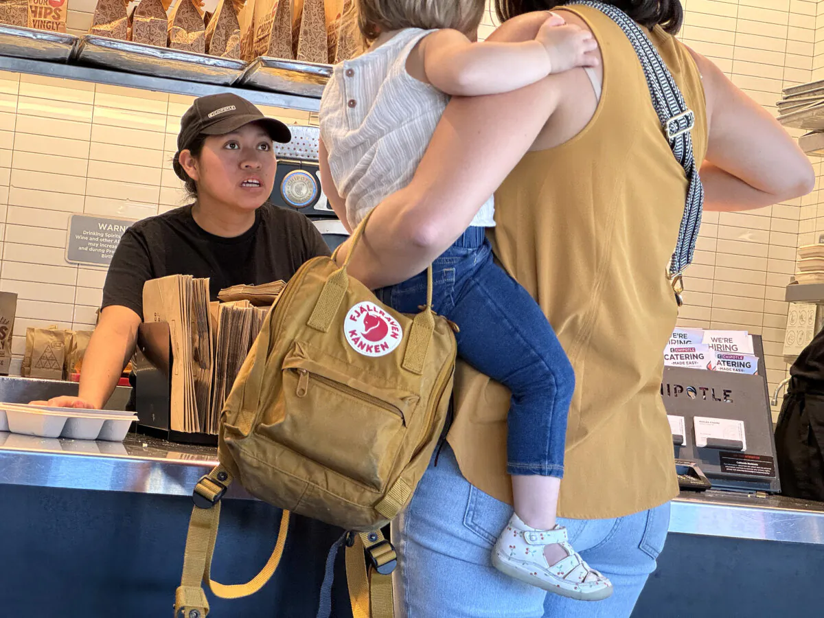 Hiking the minimum wage to $20 for California's fast-food workers will result in job losses, higher prices, and more automation. Pictured: An employee helps a customer at a Chipotle restaurant in San Rafael, Calif., on April 1, 2024. (Justin Sullivan/Getty Images)
