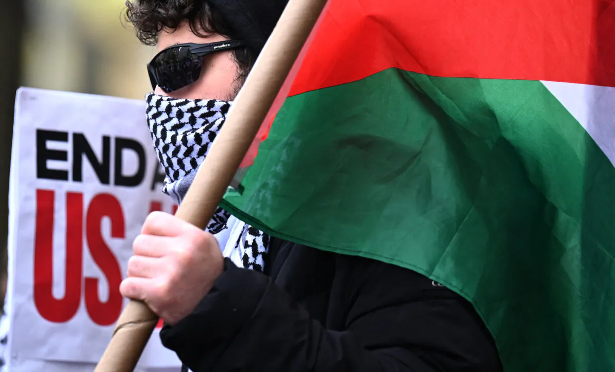A pro palestinian protester carries a palestinian flag outside the Columbia University campus in New York City, on April 24, 2024. (Timothy Clary/ AFP)