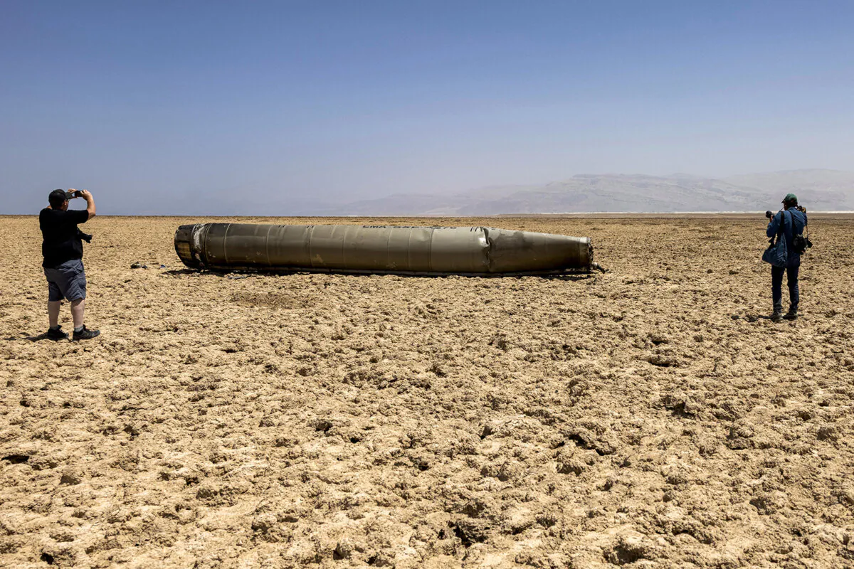 Photographers film the remains of a missile that landed on the shore of the Dead Sea, a week after the missile barrage fired by Iran on April 13, on April 21, 2024. Iran on April 13 launched more than 300 drones and missiles at Israel in a late night attack that caused little damage after most of the projectiles were intercepted. (Menahem Kahana/AFP via Getty Images/TNS)