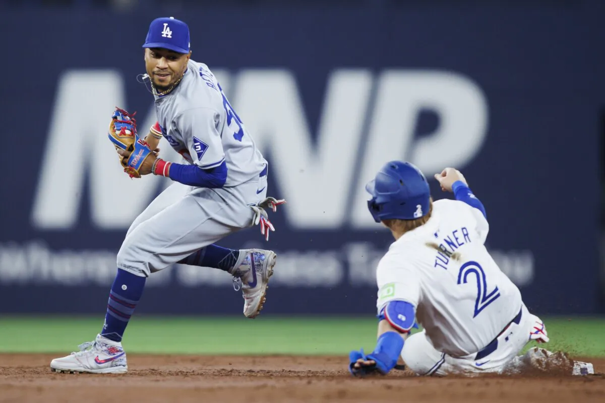 Mookie Betts (50) of the Los Angeles Dodgers smiles at Justin Turner (2) of the Toronto Blue Jays after tagging Turner out at second base in the second inning of their MLB game in Toronto on April 26, 2024. (Cole Burston/Getty Images)