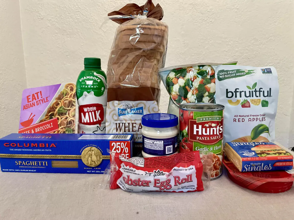 Food purchased from the Dollar Tree store within a $20 budget include milk, frozen vegetables, dried fruit, wheat bread, pasta sauce, dry pasta, frozen noodles, mayonnaise, a frozen lobster egg roll, cheese, and lunch meat. (Jenn Harris/Los Angeles Times/TNS)