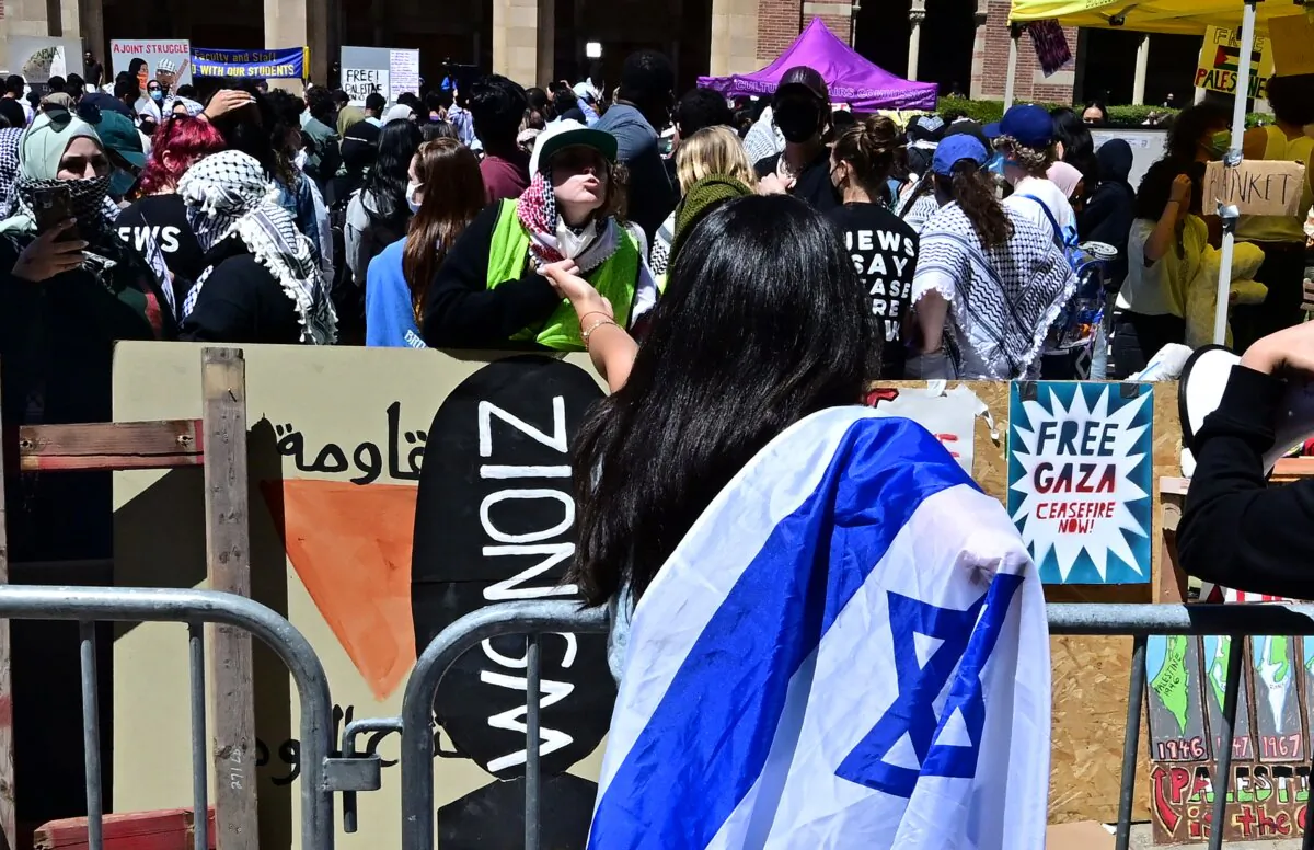 Pro-Israeli and pro-Palestinian supporters confront each other separated by metal barriers surrounding the encampment of pro-Palestinian demonstrators at the University of California in Los Angeles (UCLA) as protests continue against the Israel-Hamas war in Gaza in Los Angeles on April 26, 2024. (Frederic J. Brown/AFP via Getty Images)