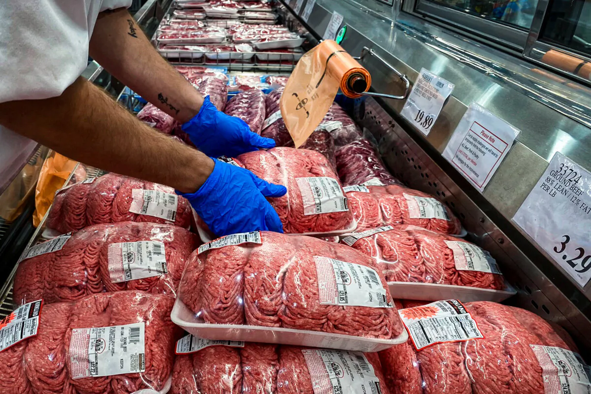 A worker stacks packets of ground beef in the meat section of a store in Webster, Texas, on May 5, 2020. (Adrees Latif/Reuters)
