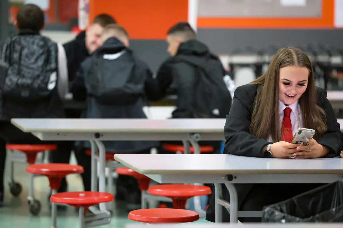 A girl reads her phone at St. Paul's High School in Glasgow, Scotland, on Aug. 12, 2020. (Jeff J Mitchell/Getty Images)