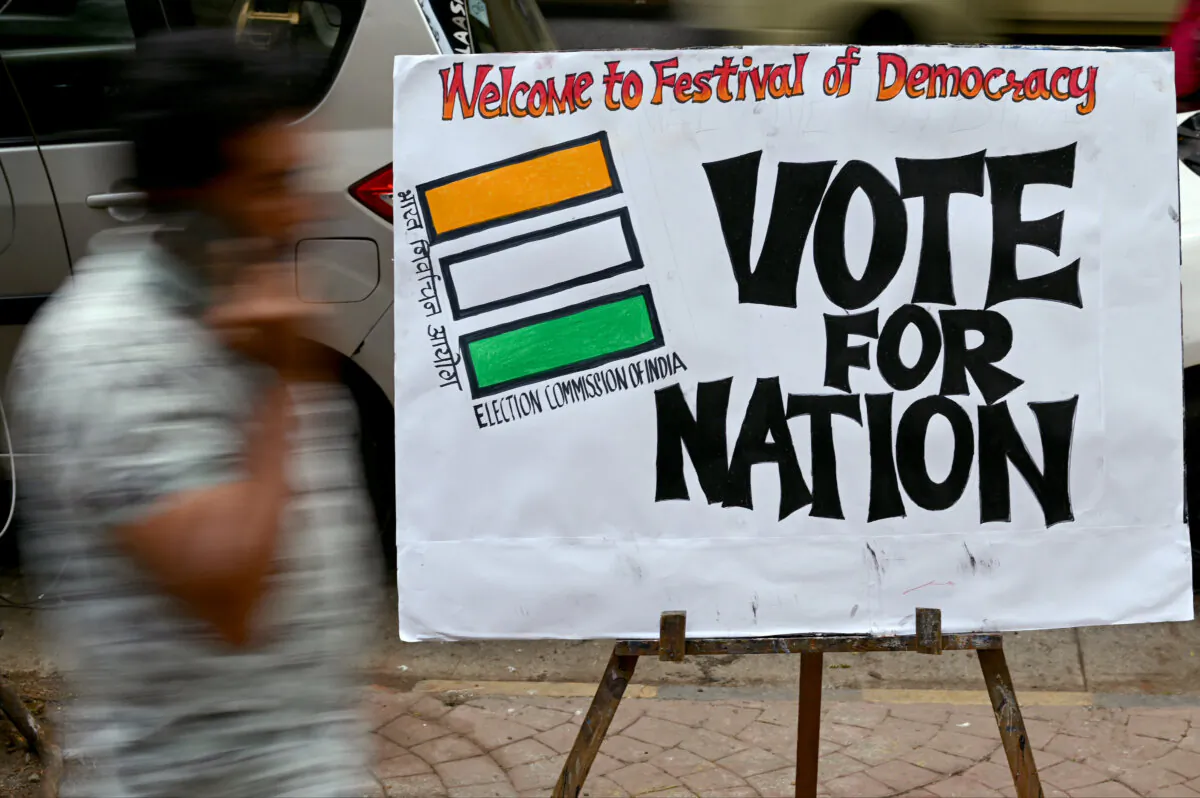 A pedestrian walks past an election themed painting placed by art students along a street outside their class to encourage people to vote in India's upcoming general elections, in Mumbai, on April 17, 2024. (Indranil Mukherjee / AFP via Getty Images)