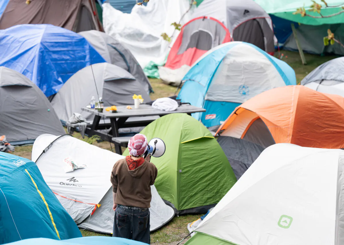 An activists uses a megaphone within a pro-Palestinian encampment set up on McGill University's campus in Montreal, April 30, 2024. (THE CANADIAN PRESS/Christinne Muschi)